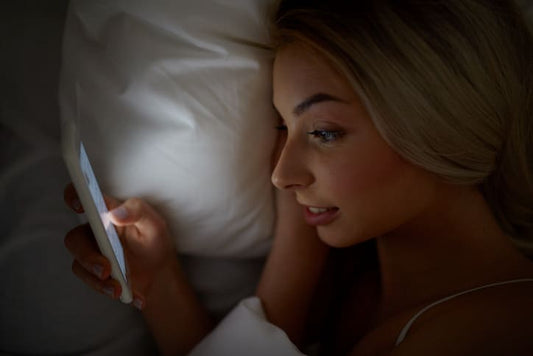 teenager using smartphone in bed