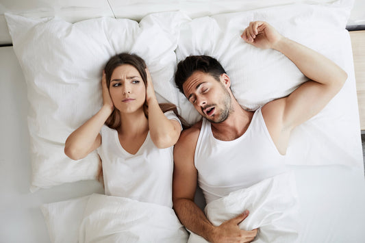 woman lying awake next to snoring husband