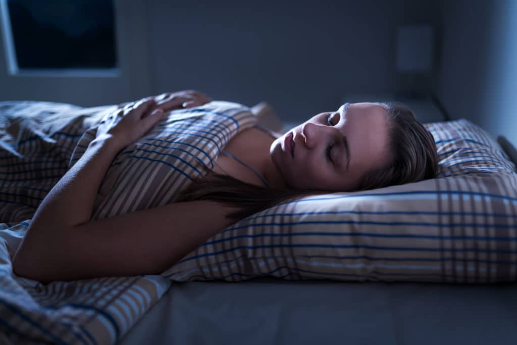 woman lying in bed in the dark