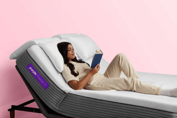 Woman reading a book on a Purple Hybrid Premier 3 bed