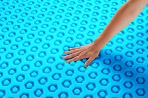 hand pushing down on a mattress