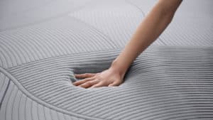 A hand pressing down on a mattress in one of our many Oregon mattress store locations