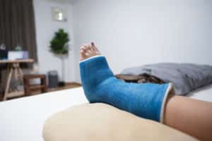 blue foot cast propped up on pillow