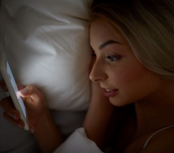 teenager using smartphone in bed