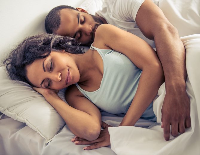 Beautiful young couple is sleeping in their bed at home