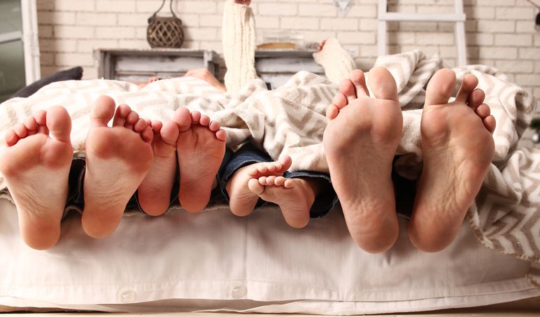 family feet sticking out over mattress