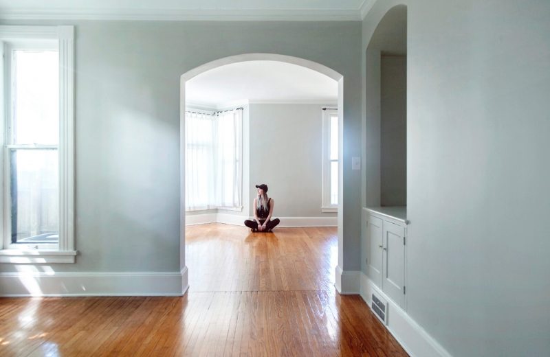 Woman sitting on the floor in an empty room of a house