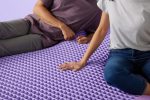 Couple sitting on Purple Hybrid Premier 4 mattress