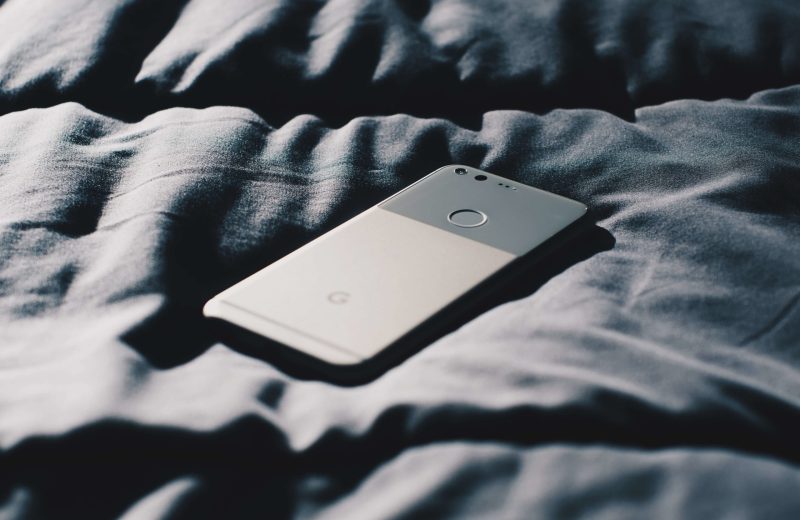 smart phone lying on a bedspread