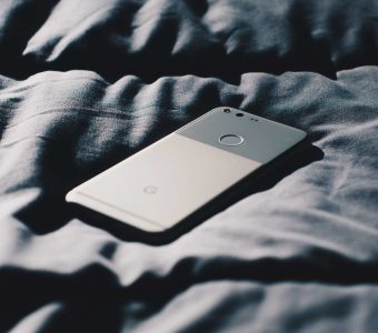 smart phone lying on a bedspread